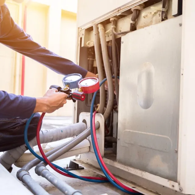 Tekniker servar ett ventilationsaggregat med manometrar